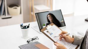 Physician engaged in a virtual interview using a laptop and wearing professional attire